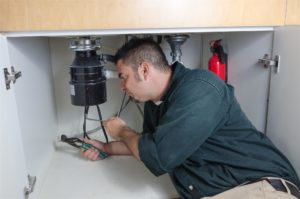 man fixing kitchen sink plumbing