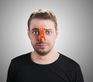 Man with clothespin on his nose