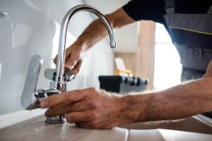 Professional plumber fixing sink as part of home maintenance tasks