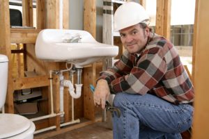 construction plumber installing bathroom fixtures