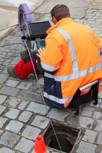 plumbe using a sewer camera for inspections