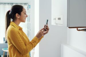 Woman managing her smart boiler using her phone