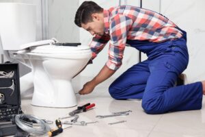 Christianson Air Conditioning and Plumbing employee working on a toilet that won't stop running