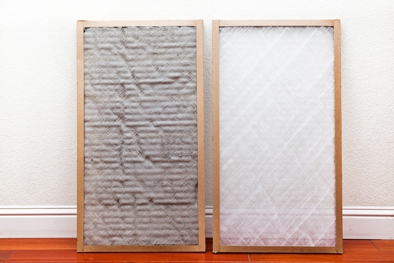 Dirty AC filter next to a clean AC filter