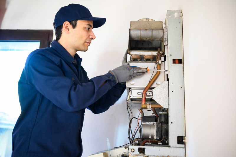 Plumber from Christianson Air Conditioning and Plumbing fixing a water heater