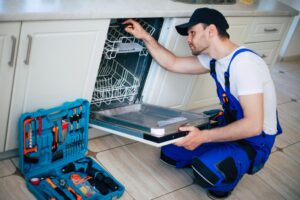 Plumber from Christianson AC&P repairing a dishwasher